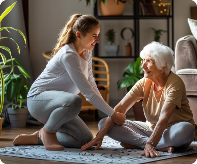 A young woman assisting an elderly lady on the ground.