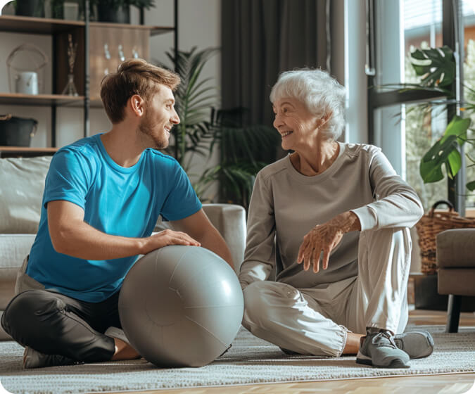 Image of a man and woman sitting on the floor, holding a ball.