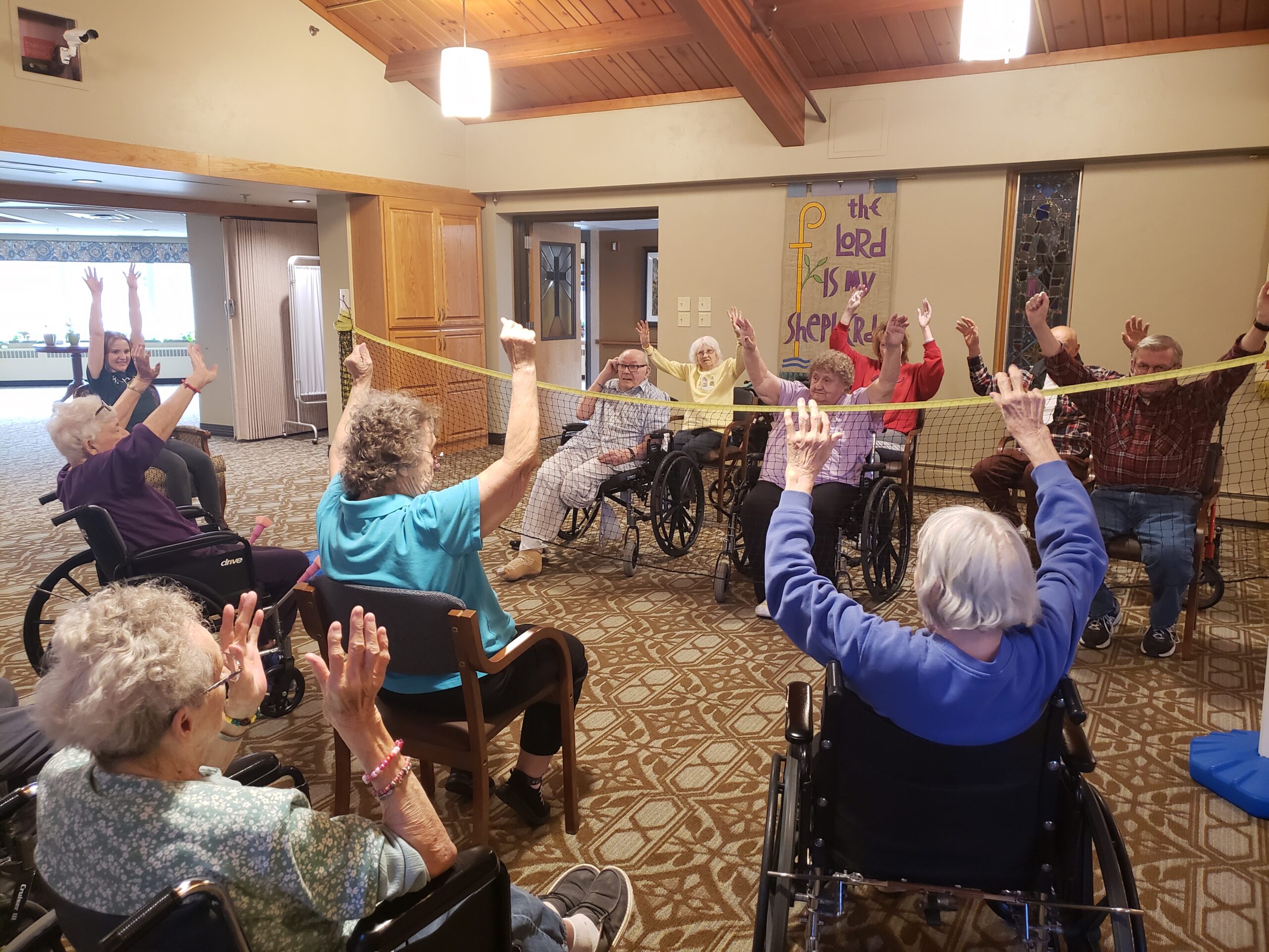 A group of elderly individuals in wheelchairs engaged in a lively game, showcasing joy and camaraderie among participants.