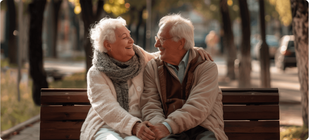 An older couple sharing a moment of companionship while sitting together on a park bench.